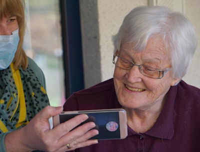 woman in brown button up shirt holding white smartphone